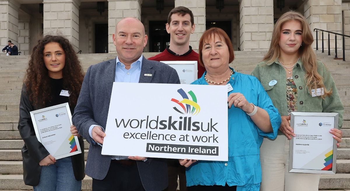 five people, three females and two males,  three holding framed certificates and two holding a WorldSkills UK logo board